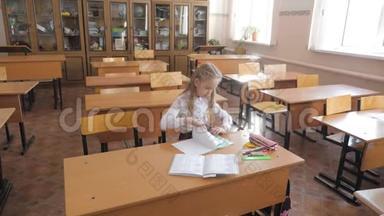 小女孩坐在学校的<strong>班级</strong>里学习。